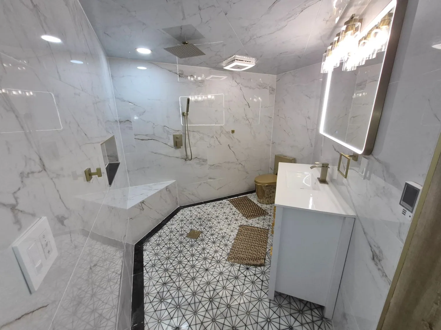 Remodeled bathroom with white marble-look tile shower and patterned floor
