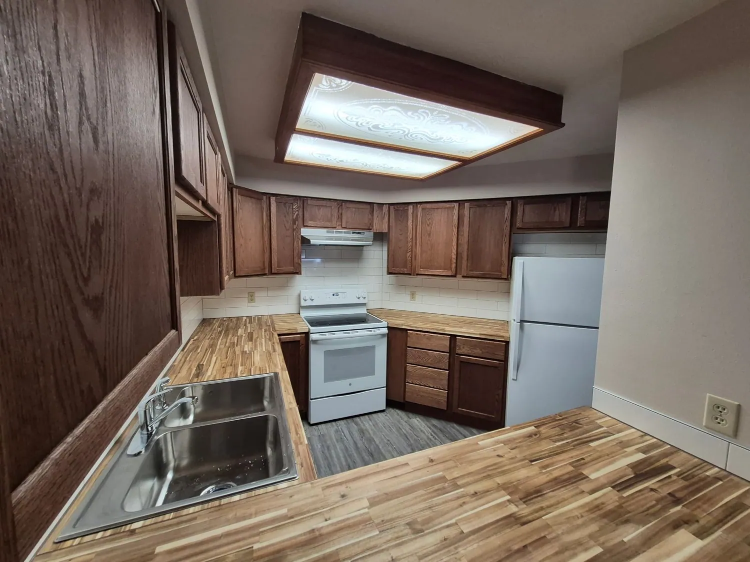 Kitchen with stained cabinets and butcher-block countertops