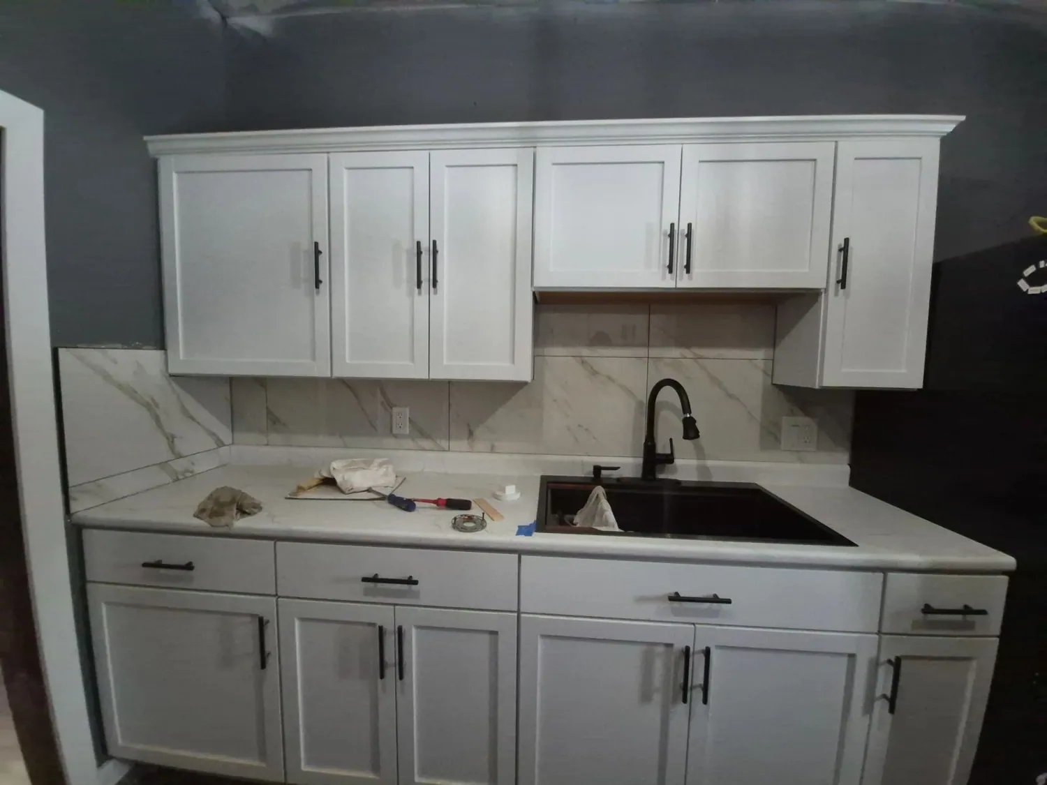 White shaker cabinets with black undermount sink
