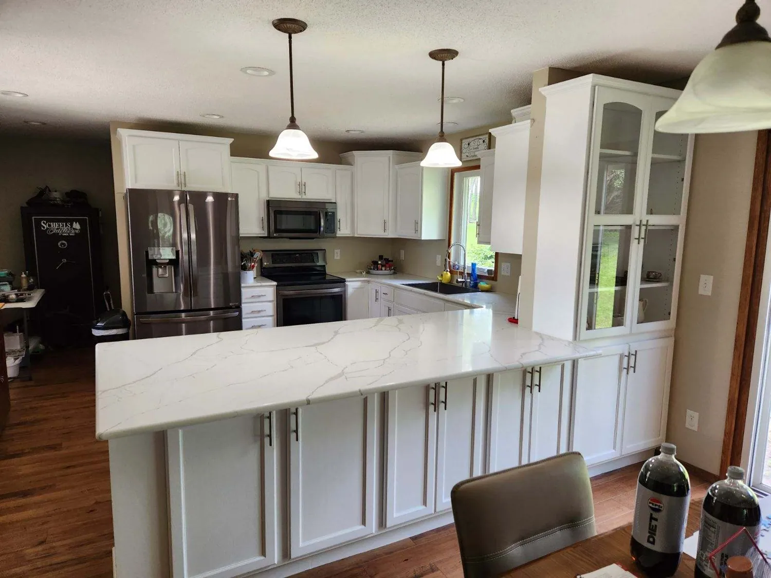 Remodeled white kitchen with quartz peninsula